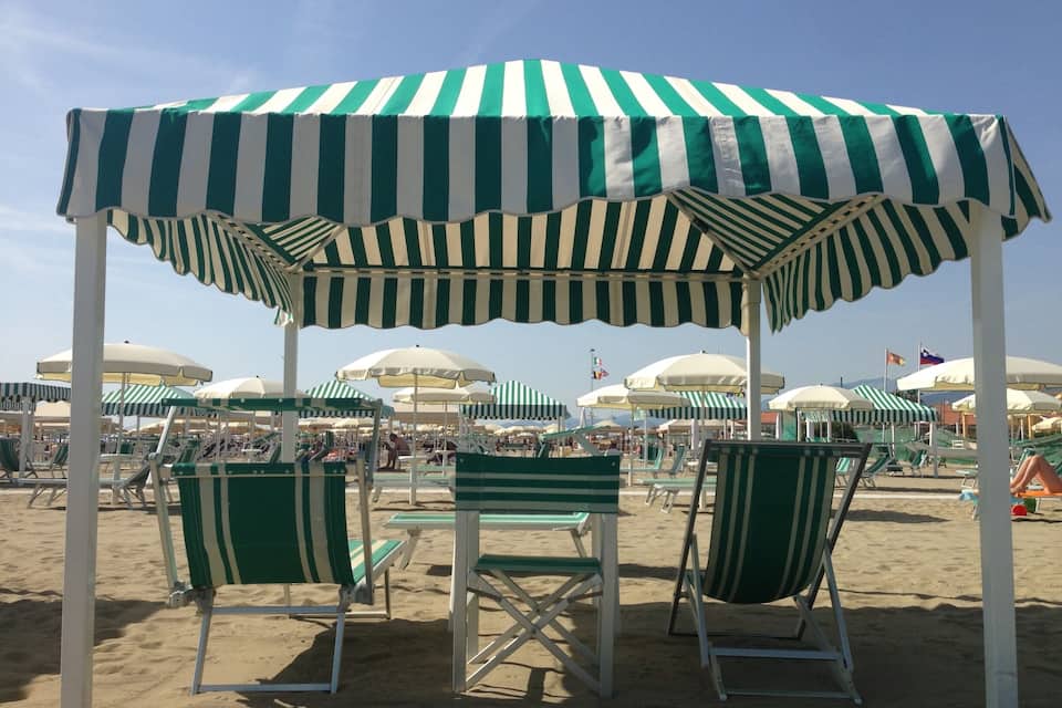Une plage avec des parasols rayés et des chaises longues.