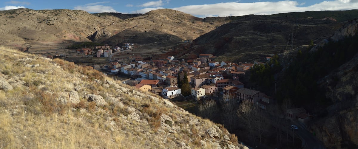 A town nestled in a valley with a mountainous backdrop.
