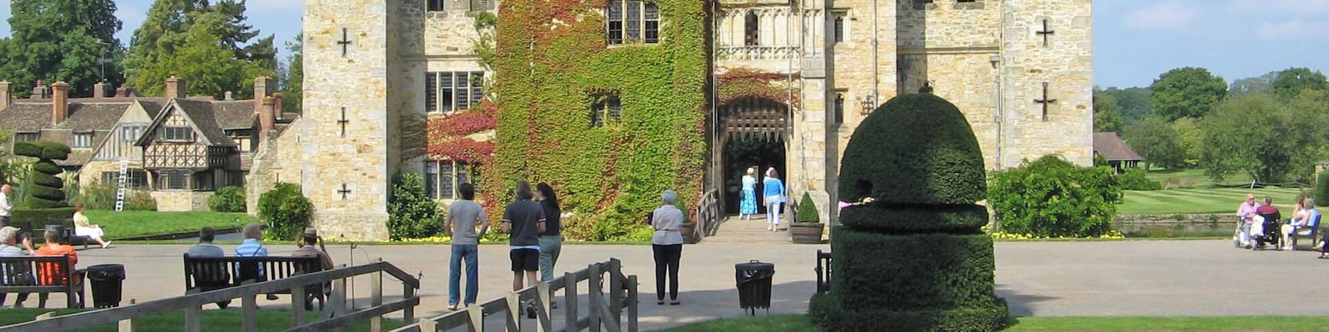 A historic castle with stone walls, a flag, and a wooden bridge.