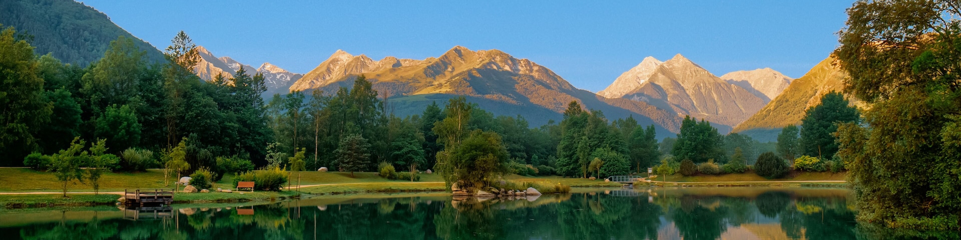 Paisaje al amanecer con lago, bosques y montañas en Saint-Lary-Soulan, en Pirineos franceses.