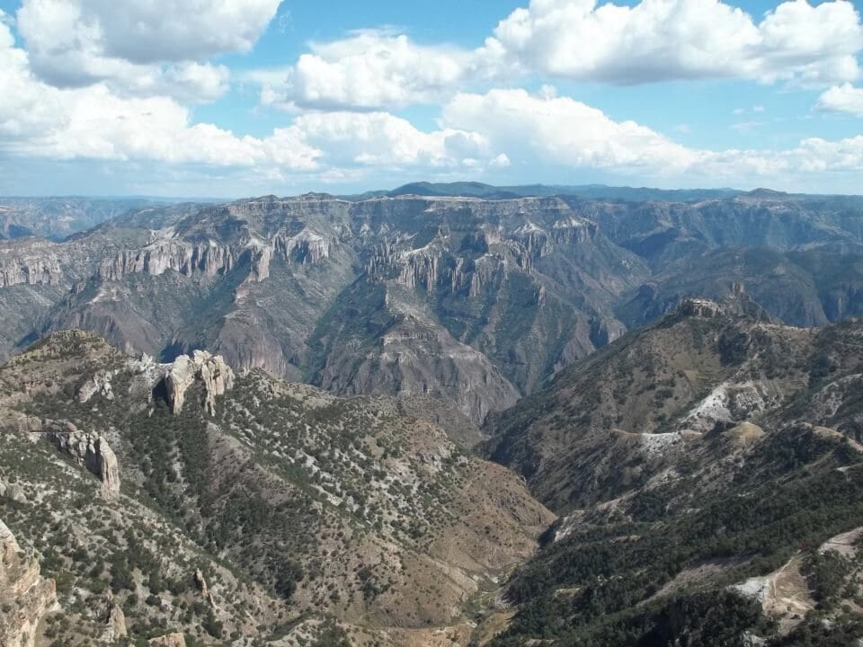 A rugged mountain landscape with steep cliffs and sparse vegetation.