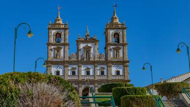 A historic church with three bell towers and a clock.