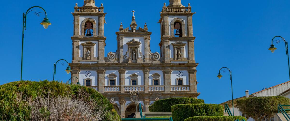A historic church with three bell towers and a clock.