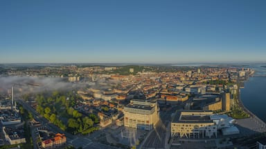 A panoramic view of a city with a river, bridges, and a fog-covered landscape.