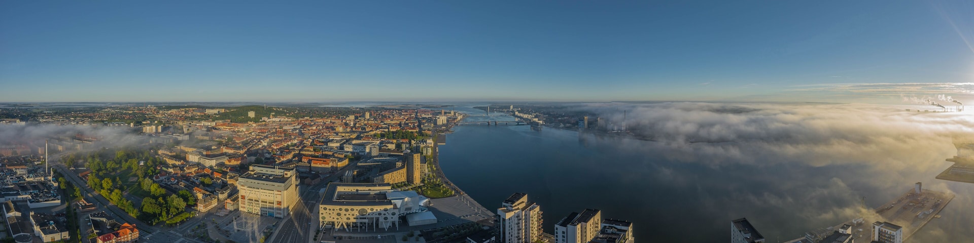 Panoramic aerial view of Aalborg city with House of Music and Aalborg port in the early morning with fog, Denmark