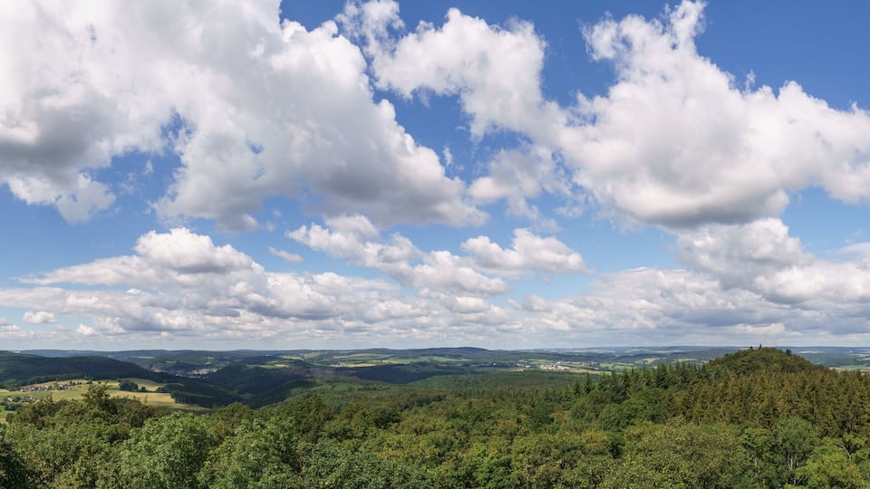 A mountainous landscape with dense forests and scattered settlements.