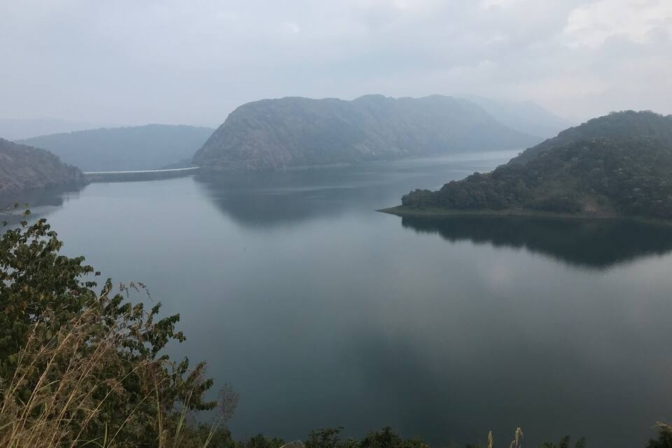 A calm lake surrounded by mountains and dense vegetation.