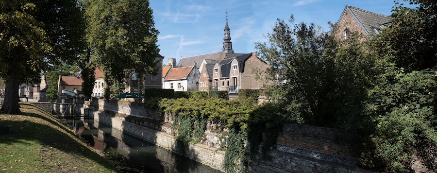 ER 13 2020: Cityscape of Tongeren, the oldest city in Belgium, on the river de Jeker with restored houses and the tower of the Begijnhofkerk in background. Widescreen image