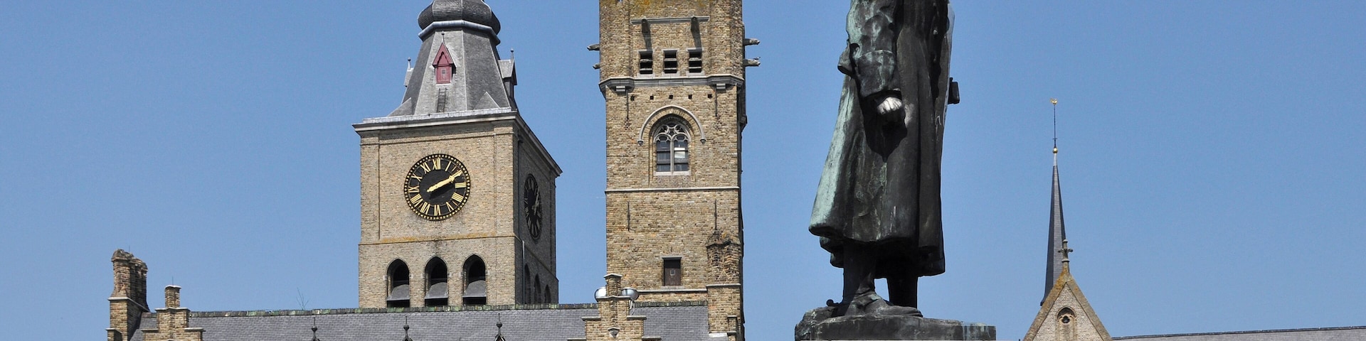 Diksmuide (Belgium): Town hall with belfry, the monument of General Jacques de Dixmude, and (in the background) the St Niklaas church