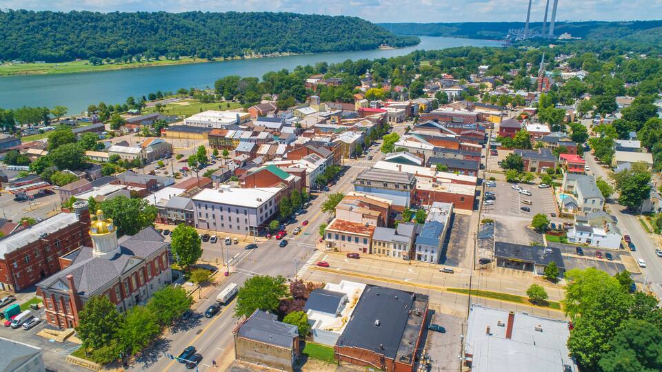 A town with a river, a bridge, and a factory with smokestacks.