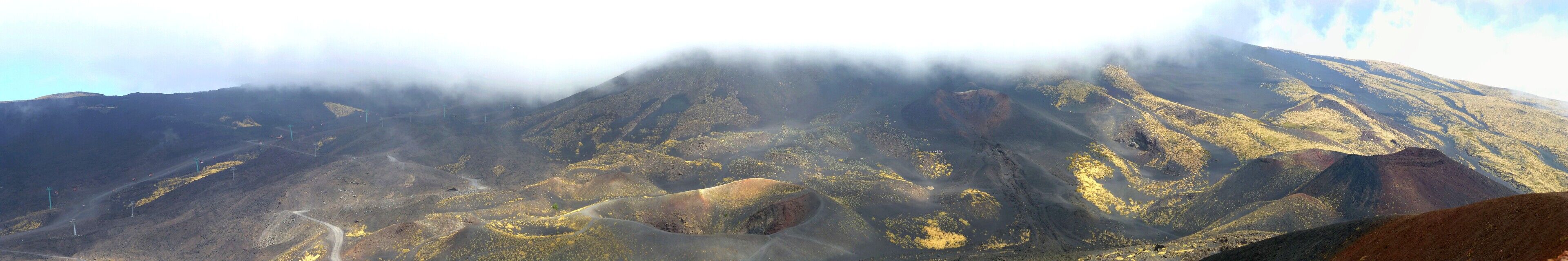 A mountainous landscape with a prominent peak partially obscured by clouds.