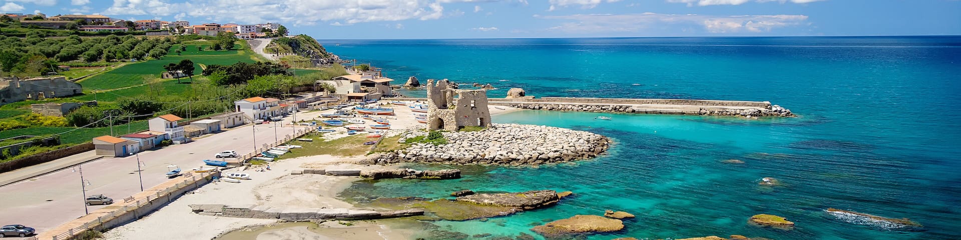 Fishing italian village Briatico in Calabria with turquoise sea and old saracen tower. Drone Panorama - Italy