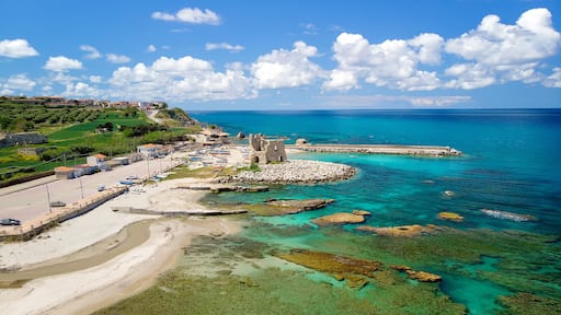 Fishing italian village Briatico in Calabria with turquoise sea and old saracen tower. Drone Panorama - Italy