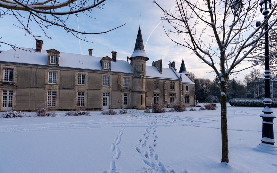 Géresme Castle under the snow a the entrance of the Parc de Géresme (Geresme Park) in Crépy-en-Valois, in the Oise department in northern France. Winter snowy landscape in Crepy-en-Valois, France.