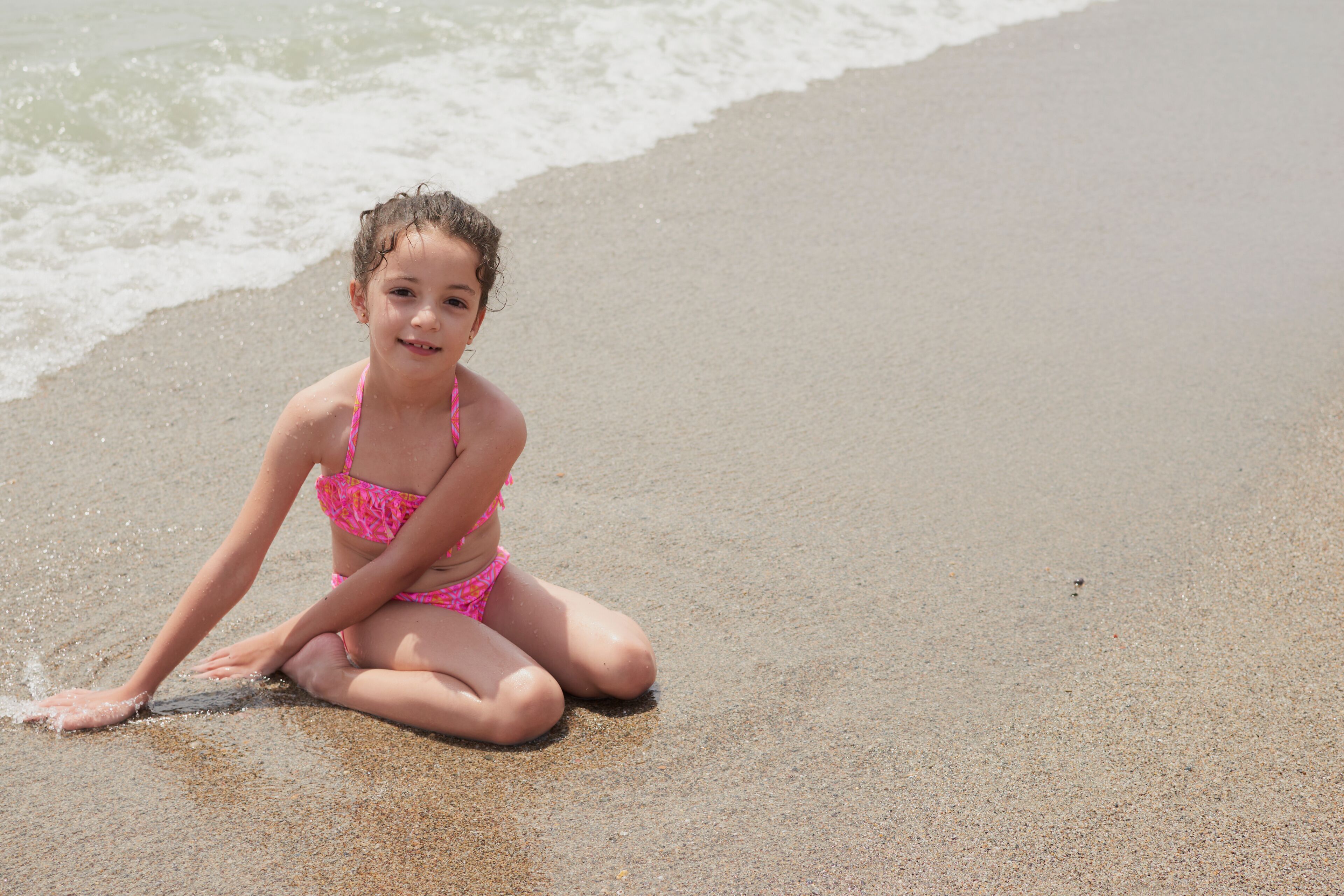 Girl playing happily on the shore of the beach, Vera, Spain