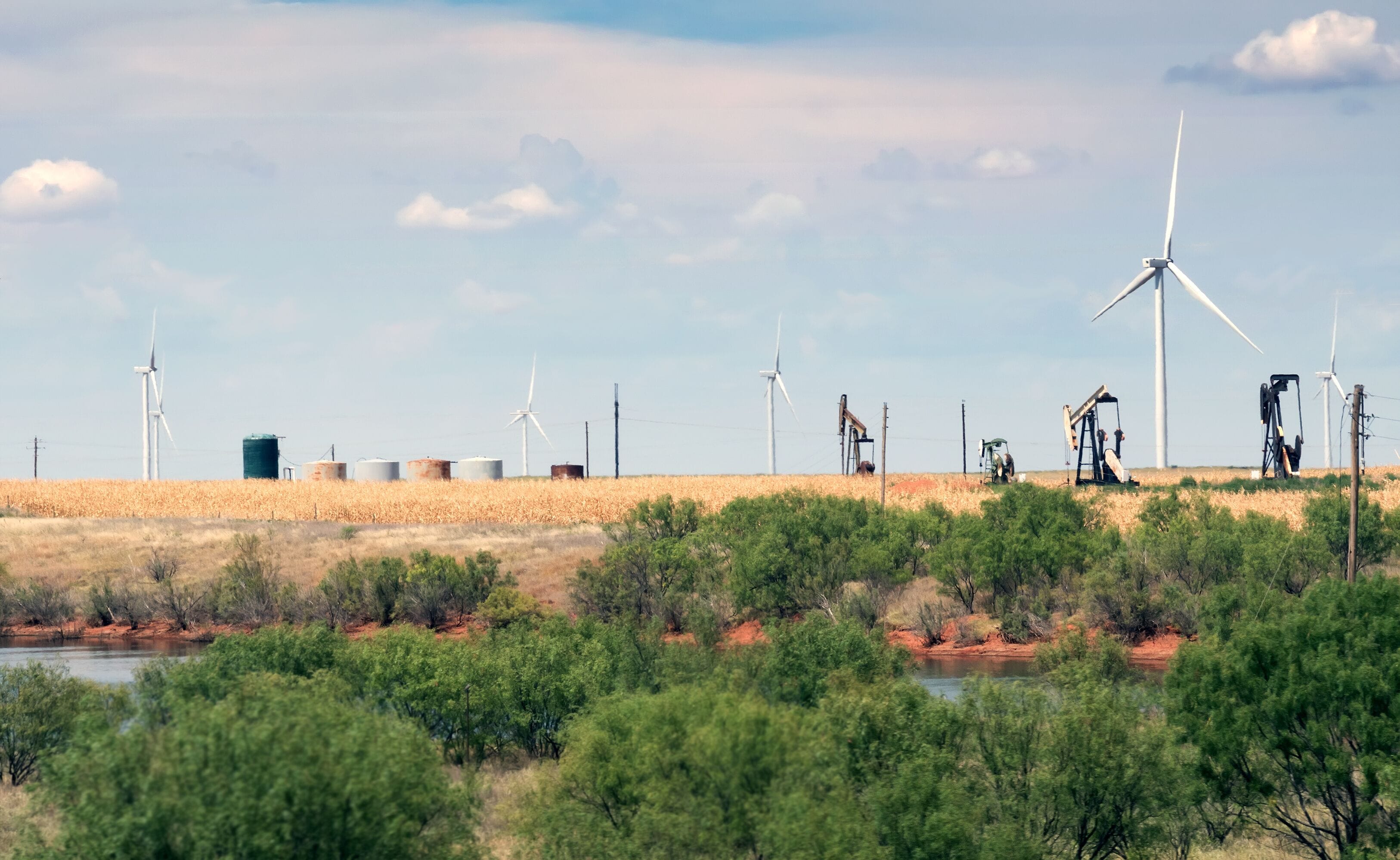 Wind turbines, oil pumps, and a dry riverbed.