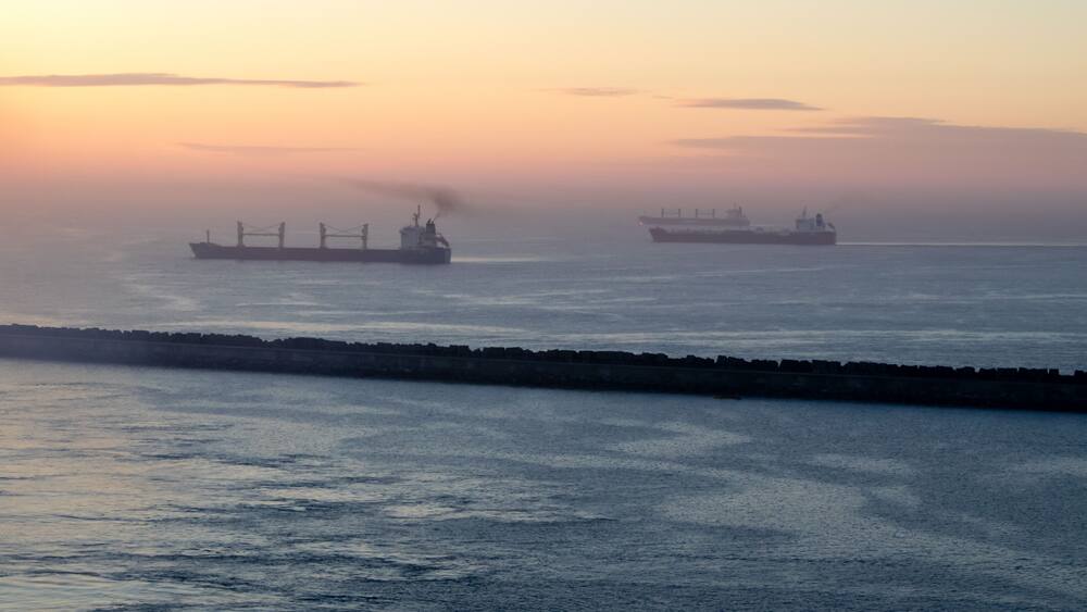 View of the Pacific Ocean in the harbor at sunrise; some ships are visible.