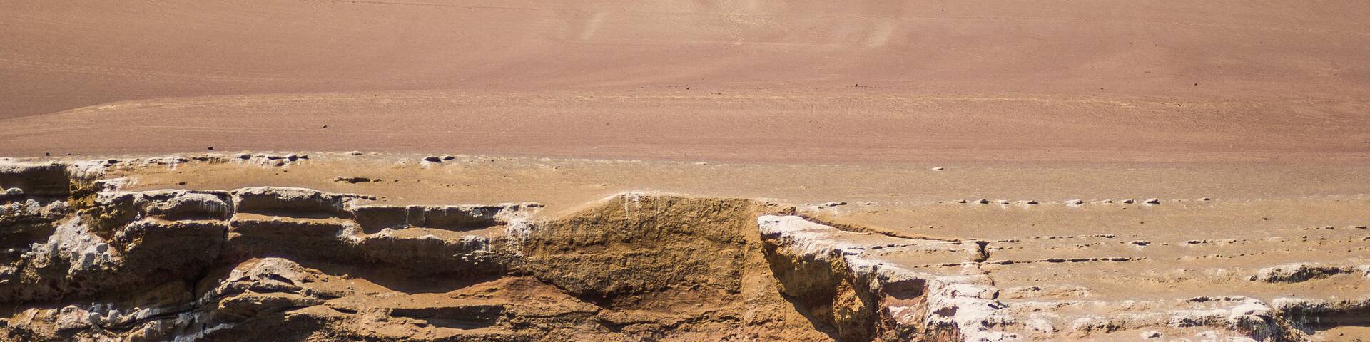 A desert landscape with large rock formations and a clear sky.