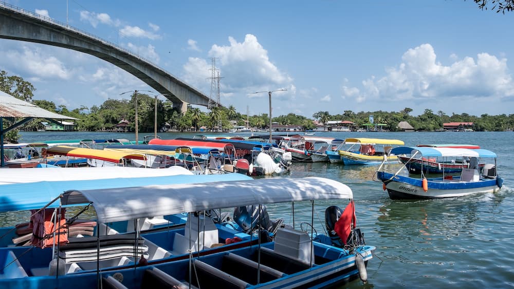 Río Dulce, Guatemala – View of Lake Izabal at the river’s source, a key ecotourism hub and gateway to rainforest canyons and Caribbean waters, with the Puente de Río Dulce in the background.