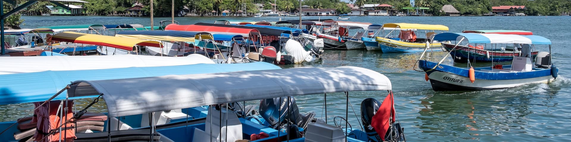 Río Dulce, Guatemala – View of Lake Izabal at the river’s source, a key ecotourism hub and gateway to rainforest canyons and Caribbean waters, with the Puente de Río Dulce in the background.