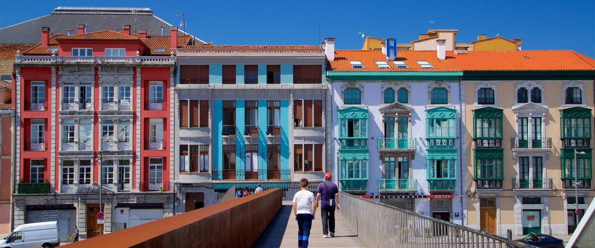 A pedestrian bridge with colorful buildings on either side.