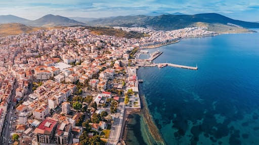 Drone panorama capturing the beauty of Dikili, a coastal town in Turkey, showcasing its colorful buildings, harbor, and the clear Aegean Sea