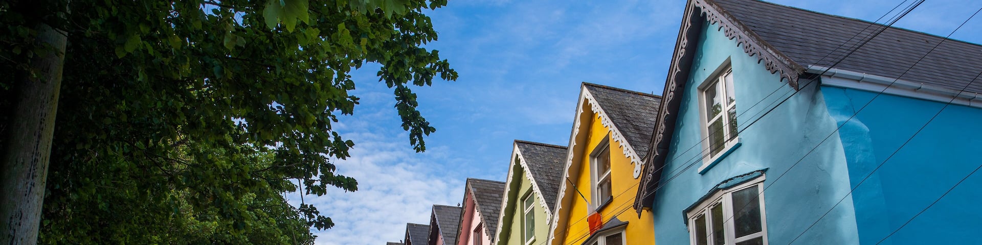 A row of colorful houses with a car parked in front.
