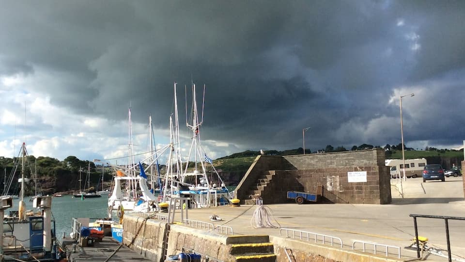 A harbor with boats, a staircase, and a cloudy sky.