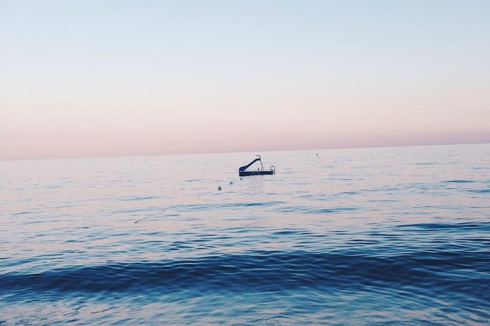 A calm sea with gentle waves and a distant boat.