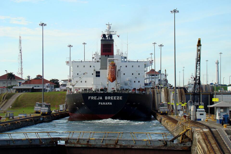 A large ship named 'FREJA BREEZE' entering a harbor.
