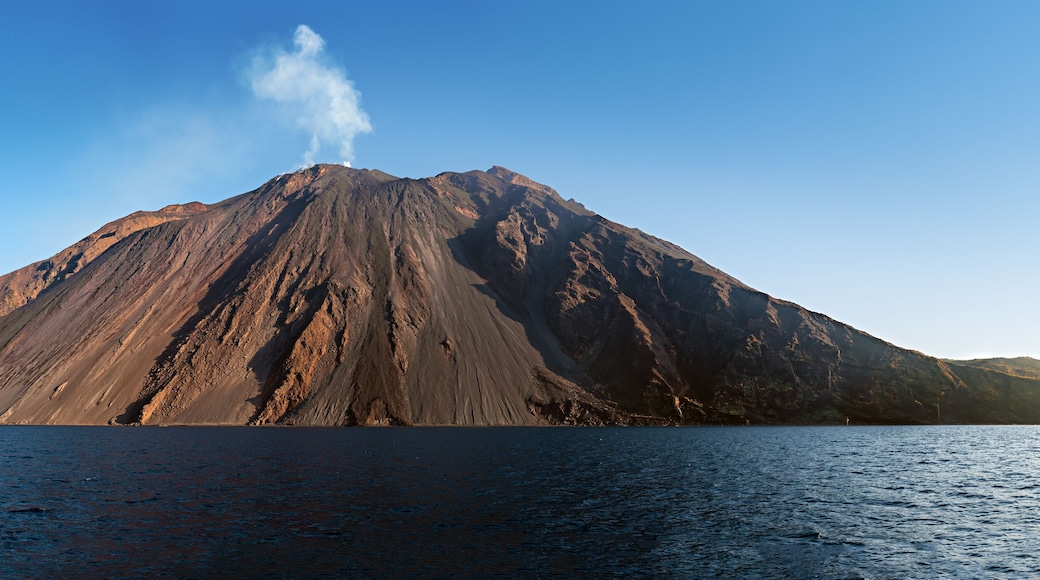 The stromboli vulcano erupting on the "Sciara del Fuoco" north west side, day shot, blue sky background, panoramic shot, eolians islands, sicily, italy