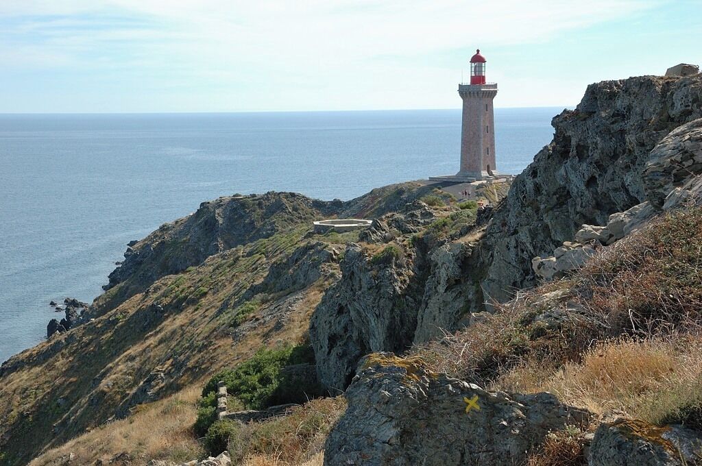A lighthouse on a rocky cliff overlooking the sea.