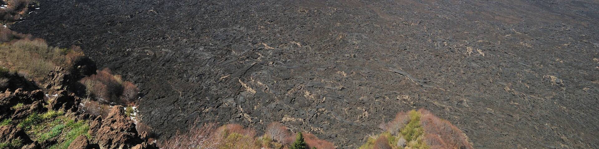 A snow-capped mountain with a visible volcanic crater emitting smoke.