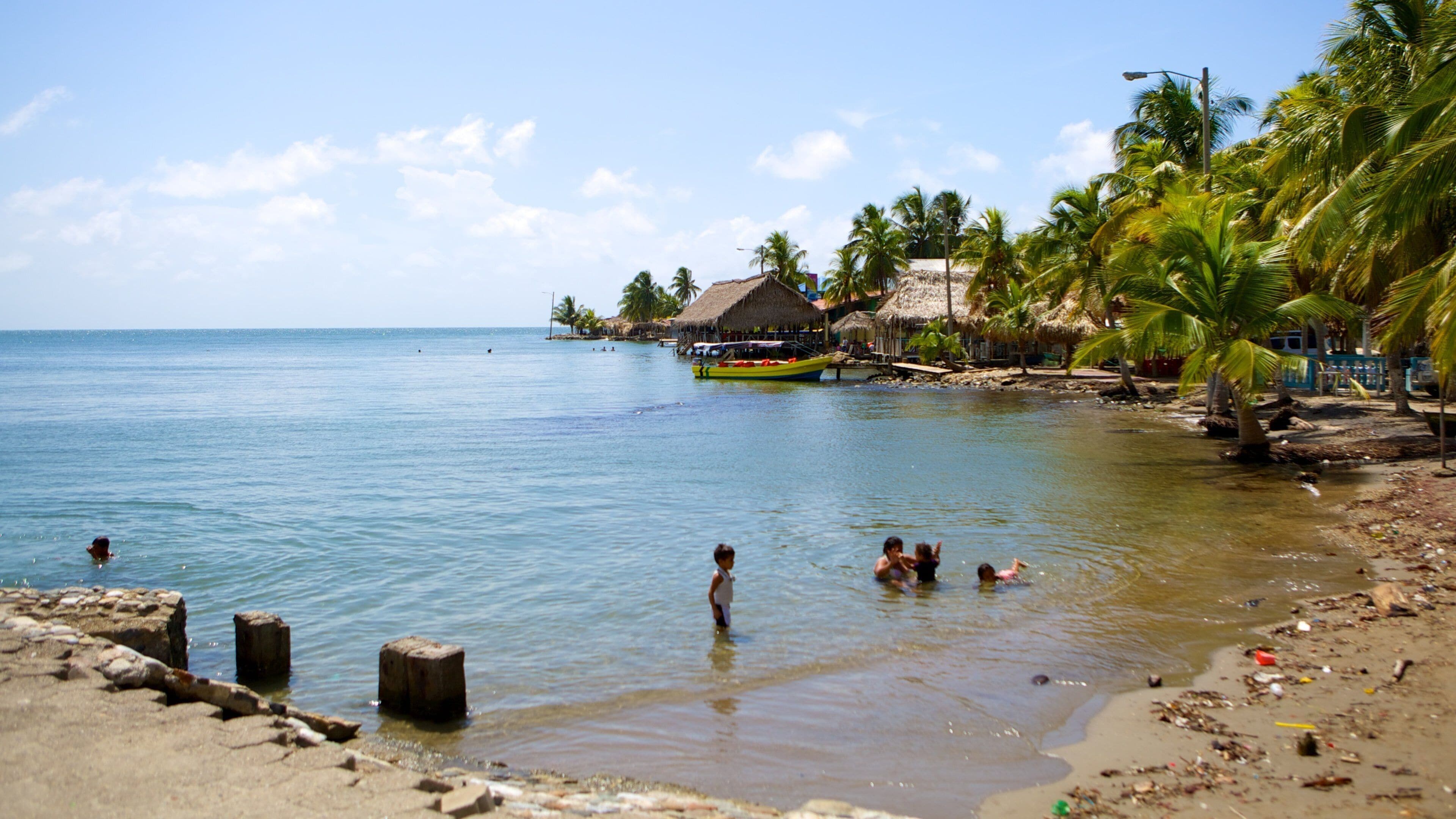 Omoa que incluye vistas generales de la costa y natación y también niños