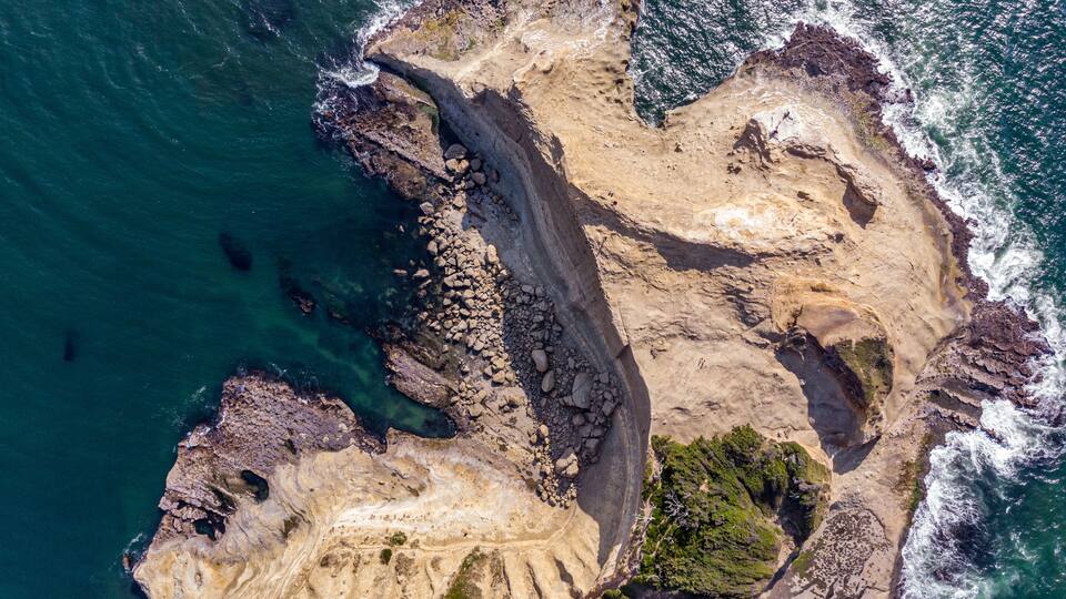 A rugged coastline with rocky cliffs and clear blue waters.
