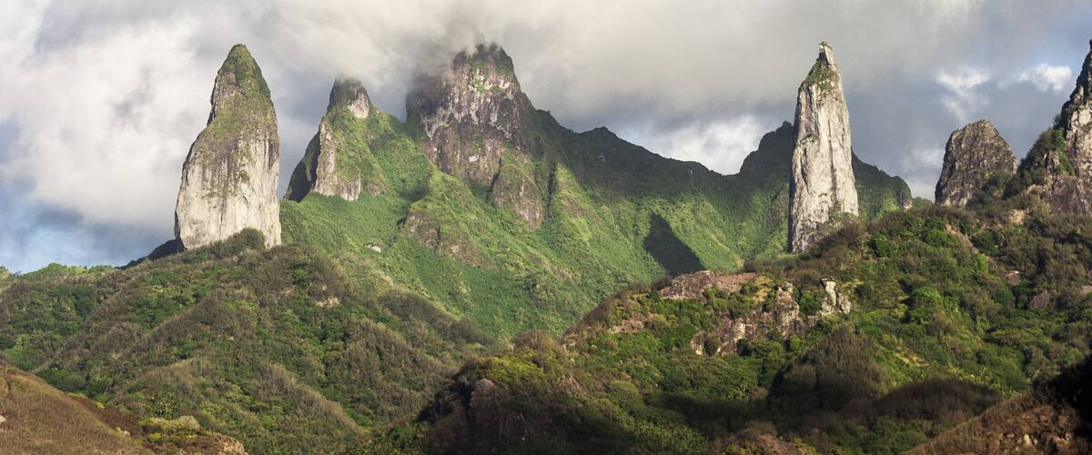 A mountainous landscape with prominent rock formations and lush green vegetation.