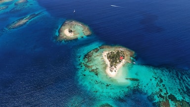 An aerial view of two small islands with clear turquoise waters and sandy beaches.