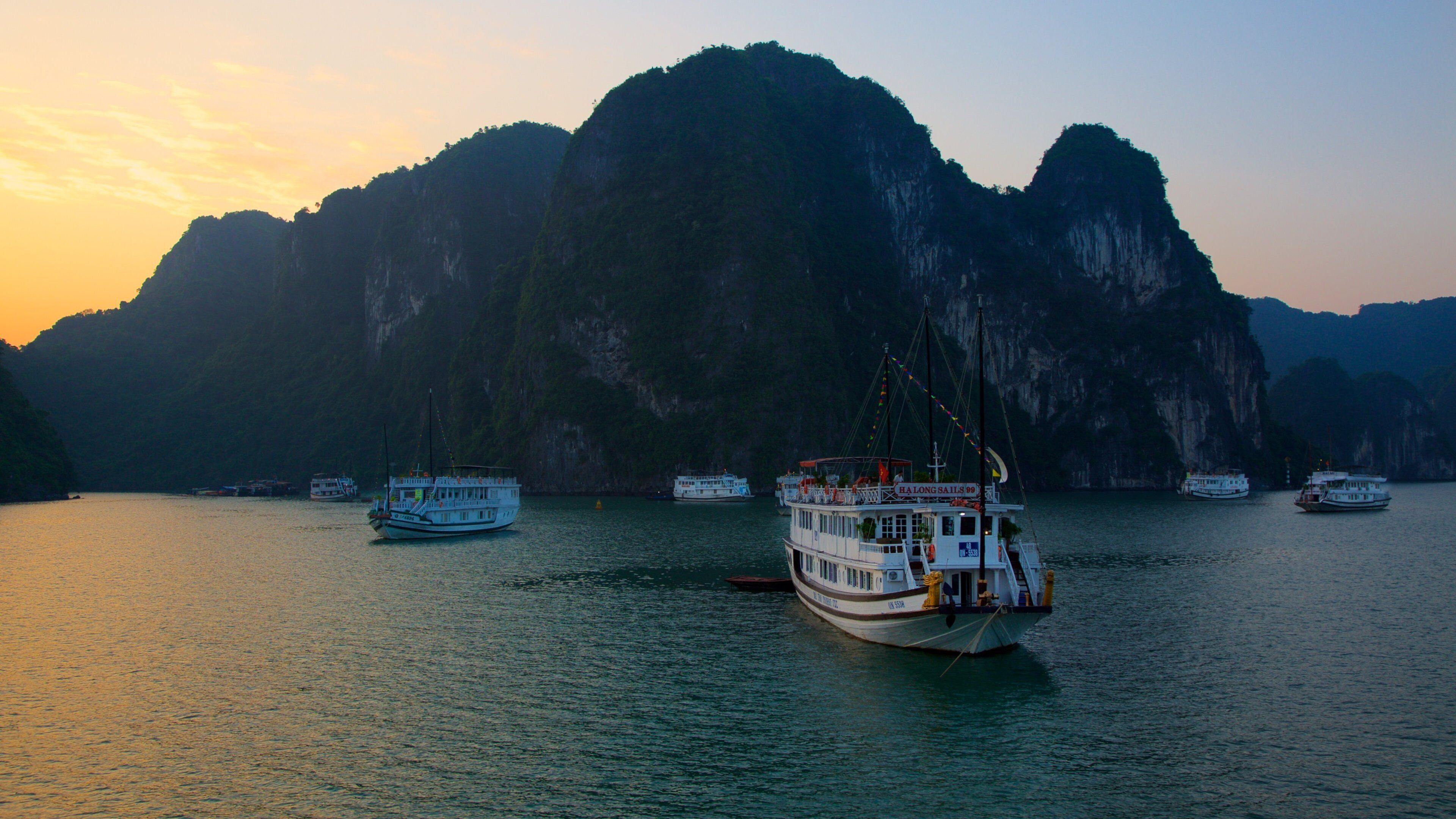 Halong Bay som viser bjerge, en solnedgang og udsigt over kystområde