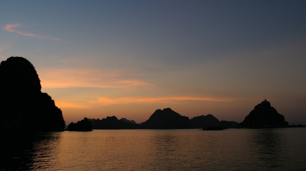 Halong Bay showing a bay or harbor, mountains and a sunset