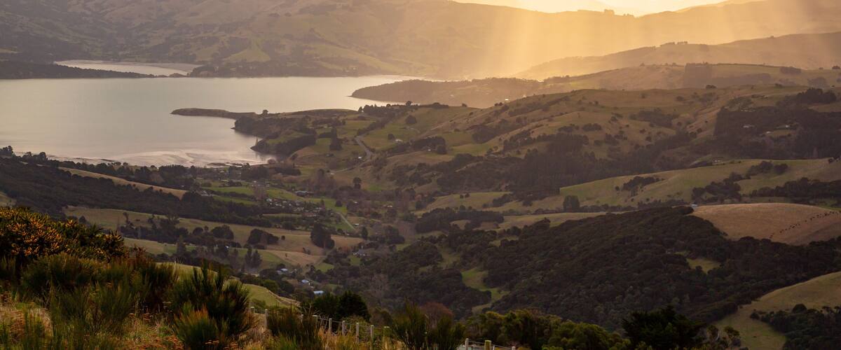 Akaroa which includes a river or creek, tranquil scenes and a sunset