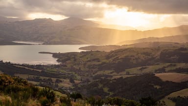 Akaroa which includes a river or creek, tranquil scenes and a sunset