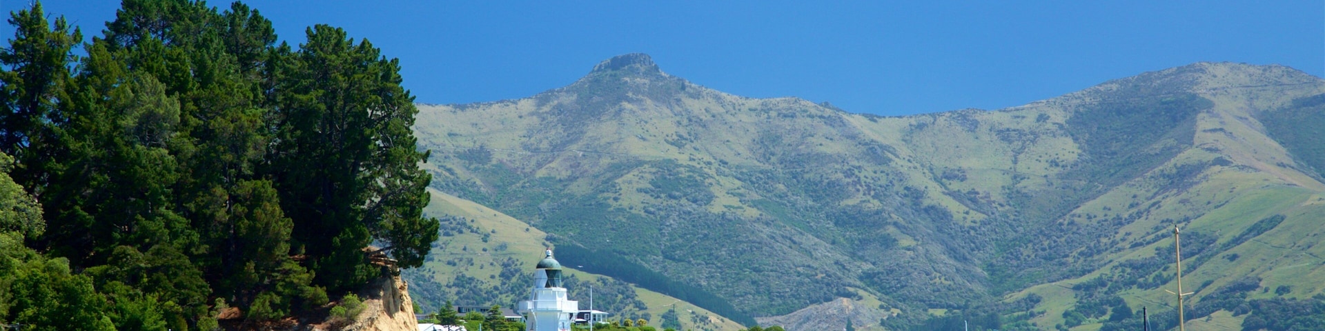 Akaroa ofreciendo escenas tranquilas, un faro y un lago o espejo de agua