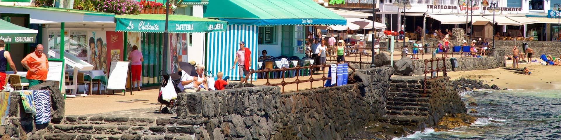 A coastal town with buildings, a beach, and a rocky shoreline.