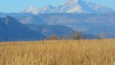View of Long's Peak and Mount Meeker in Rocky Mountains Colorado with dry autumn prairie grass on foreground