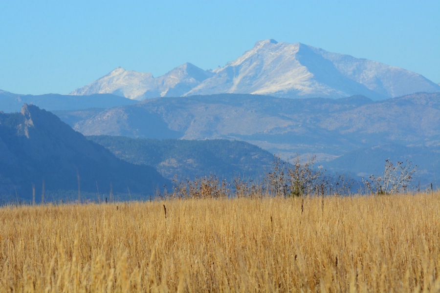 View of Long's Peak and Mount Meeker in Rocky Mountains Colorado with dry autumn prairie grass on foreground