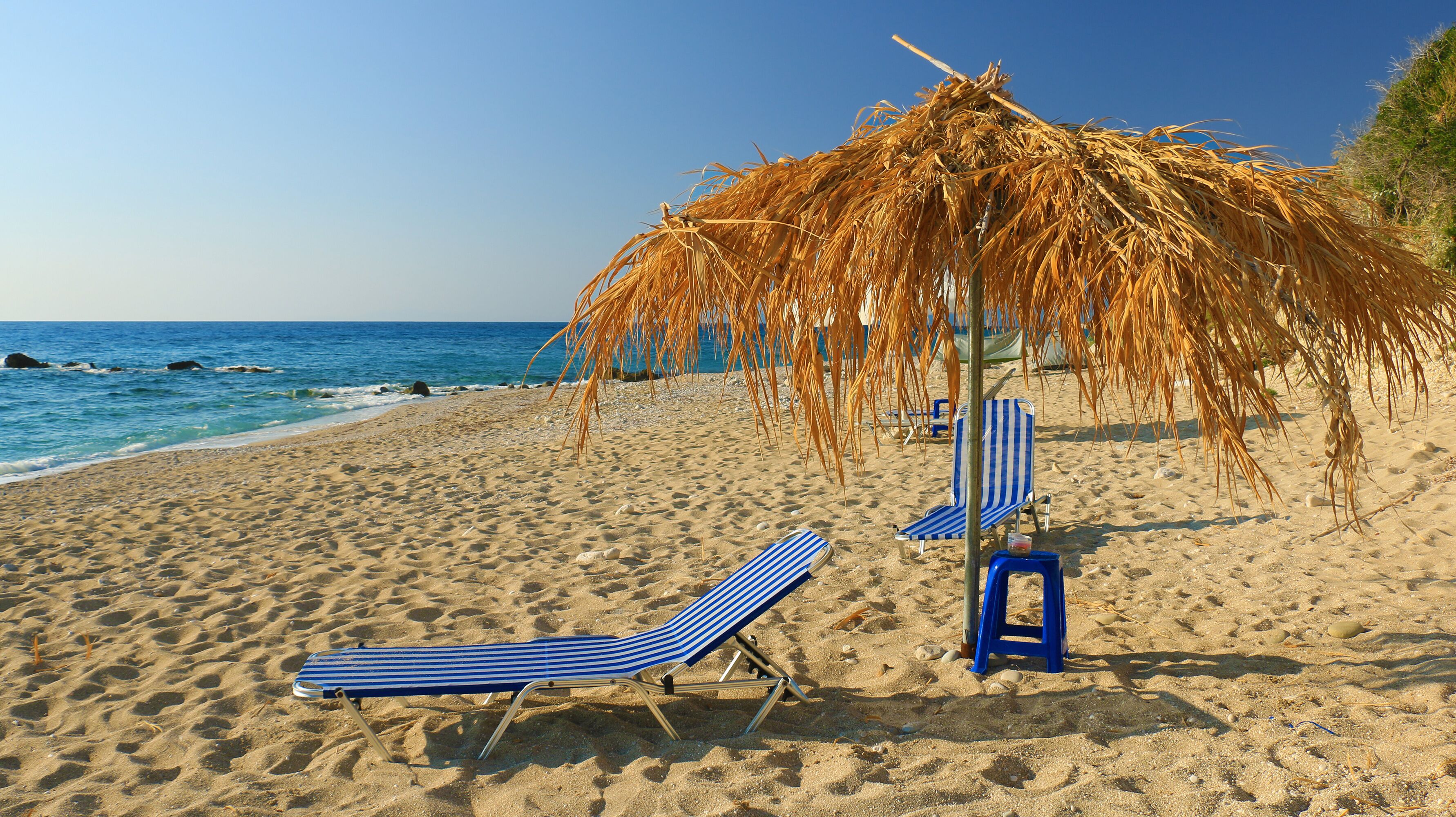 straw beach umbrella with blue sky