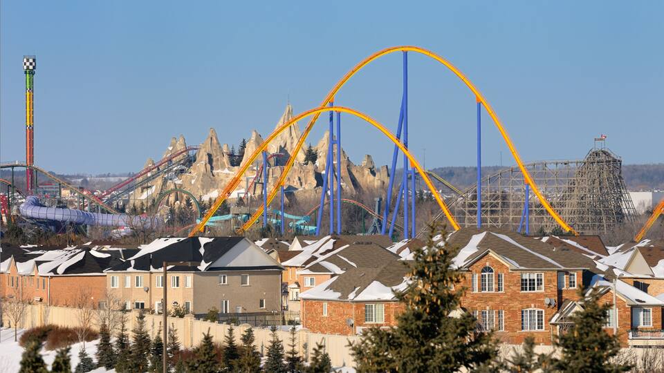 Closed amusement rides in winter next to a residential housing development near Toronto