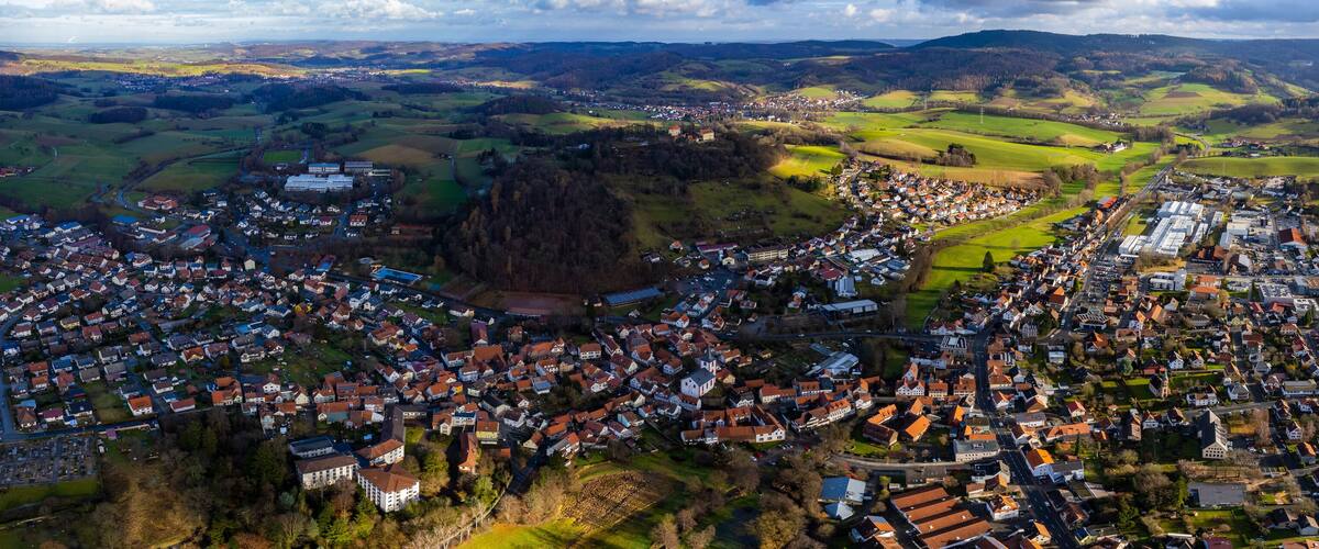 A town nestled in a valley with surrounding hills and a river.
