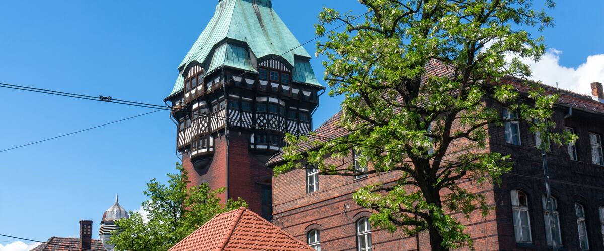 A historic building with a prominent tower and a red-tiled roof.