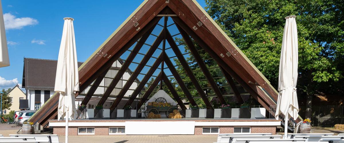 A pavilion with a triangular roof and benches in front.